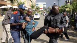 A security officer helping an injured woman to safety during the Westgate Mall attack. Image Source: http://bit.ly/1AgjaBb