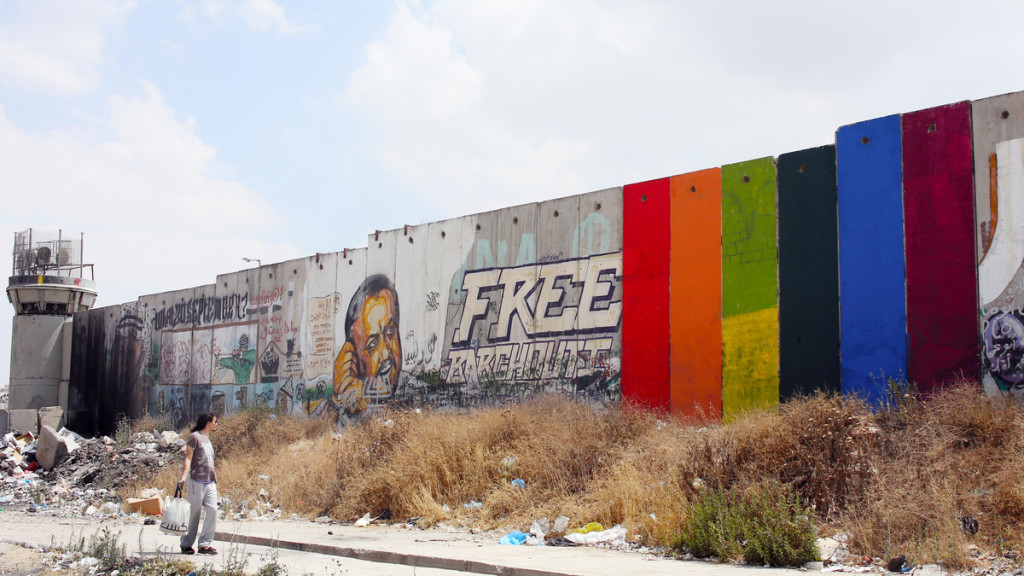 Khaled Jarrar’s rainbow mural “Through the Spectrum” painted on the Israeli separation wall near Qalandiya checkpoint in the occupied West Bank. [Credit: KHALED JARRAR]